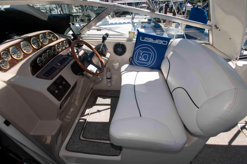 Slide: The Image of Cockpit of 2000 Rinker Fiesta Vee 310 with white seating and wooden steering wheel. - 4