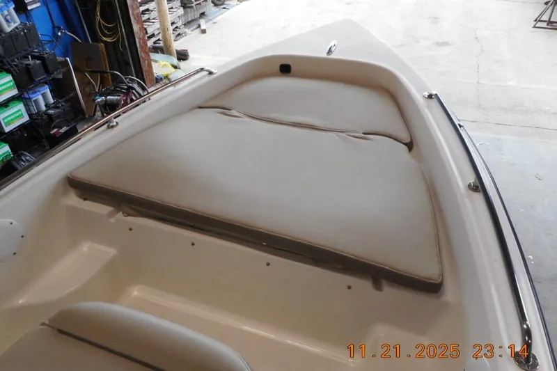 Slide: The Image of 2022 Key West 1720 Center Console boat interior with cushioned seating in a garage. - 11