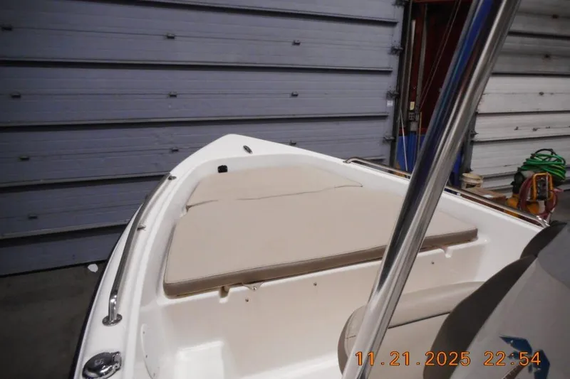 Slide: The Image of 2022 Key West 1720 Center Console boat interior with beige seating in a garage. - 5