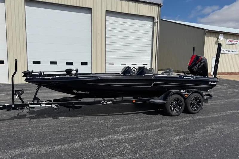The Image of 2026 Bass Cat Jaguar STS boat on trailer, parked outside a warehouse. - 0