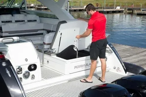 Slide: The Image of Man handling storage on 2019 Formula 430 Super Sport Crossover boat at dock. - 17
