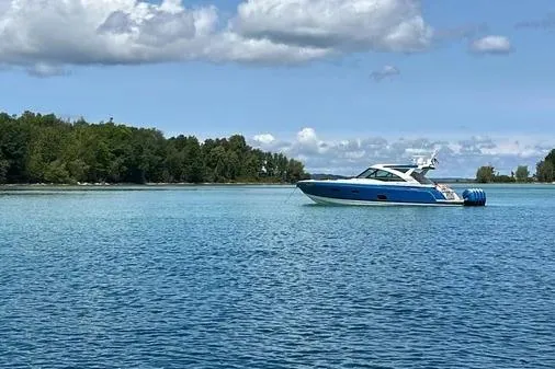Slide: The Image of 2019 Formula 430 Super Sport Crossover on serene blue water with lush green shoreline. - 3