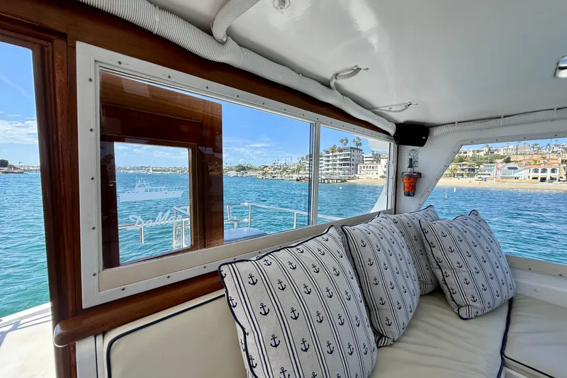 Slide: The Image of Interior view of 1980 Roughwater 41 yacht with nautical-themed cushions and scenic waterfront. - 13