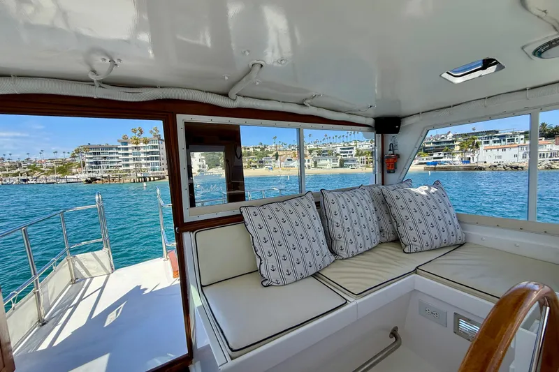Slide: The Image of Interior of 1980 Roughwater 41 yacht with coastal view and nautical-themed cushions. - 14