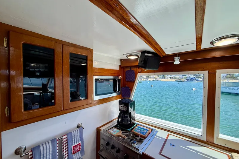 Slide: The Image of Interior of 1980 Roughwater 41 boat with wooden cabinets and ocean view through windows. - 22