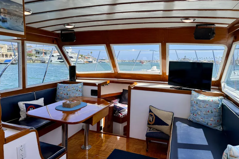 Slide: The Image of Interior of 1980 Roughwater 41 boat with seating, table, and waterfront view. - 30