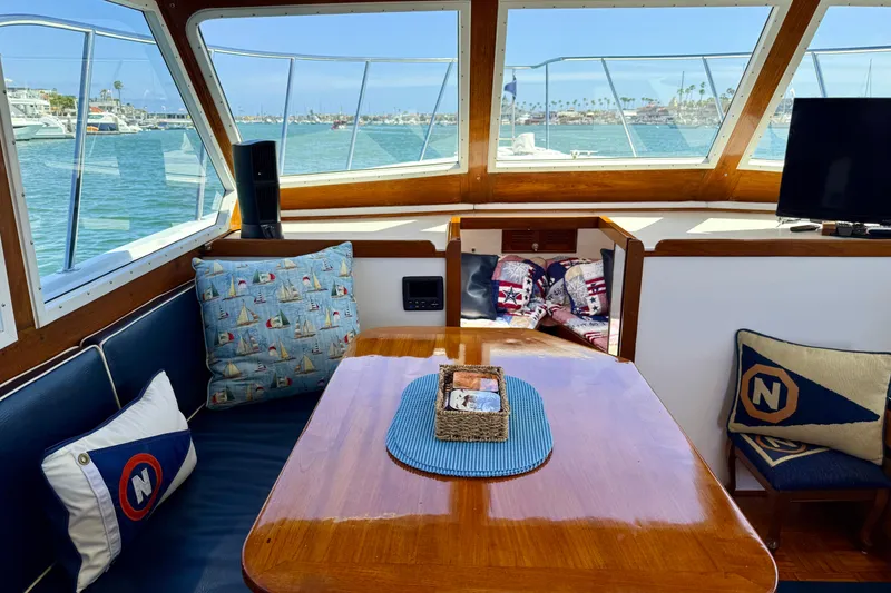 Slide: The Image of Interior of 1980 Roughwater 41 boat with nautical-themed cushions and scenic marina view. - 31