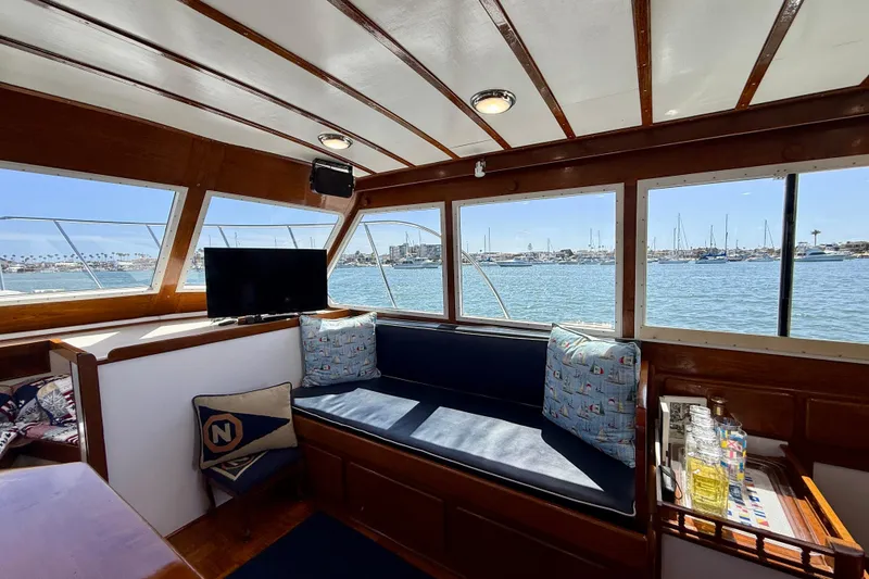 Slide: The Image of Interior of 1980 Roughwater 41 boat with harbor view, cozy seating, and TV. - 32