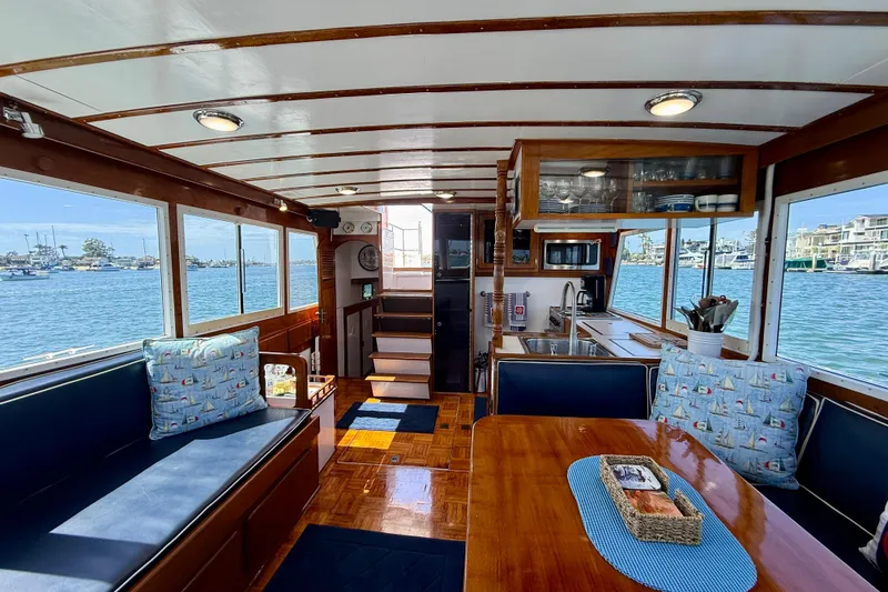 Slide: The Image of Interior of 1980 Roughwater 41 boat with wood finishes and nautical-themed cushions. - 34