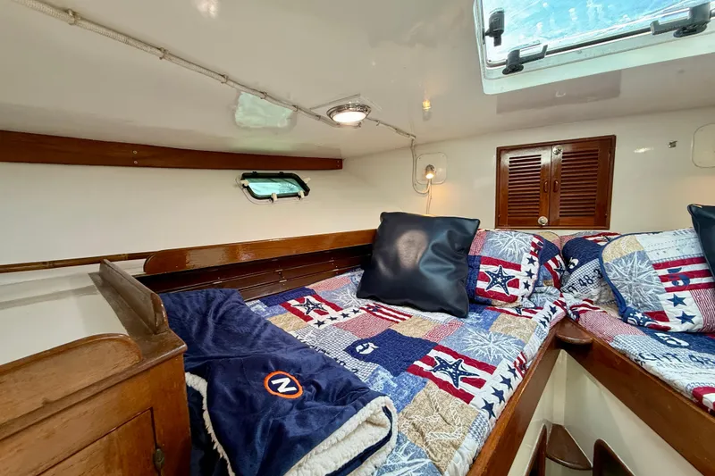 Slide: The Image of Cozy cabin interior of 1980 Roughwater 41 boat with nautical-themed bedding. - 36
