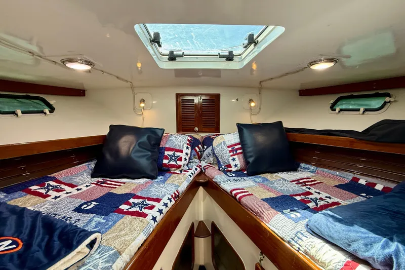 Slide: The Image of Cozy cabin interior of 1980 Roughwater 41 boat with twin beds and nautical-themed bedding. - 37