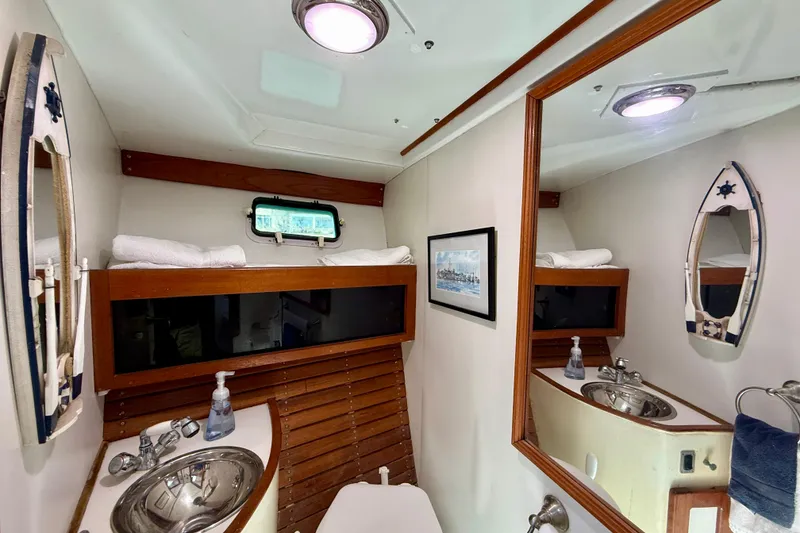 Slide: The Image of 1980 Roughwater 41 yacht bathroom with sink, mirror, and nautical decor. - 39