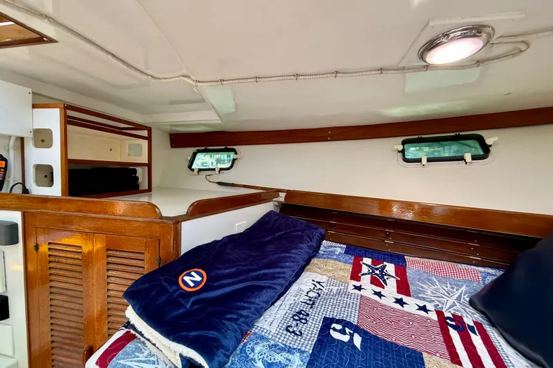 Slide: The Image of Cozy cabin interior of 1980 Roughwater 41 boat with nautical-themed bedding. - 40