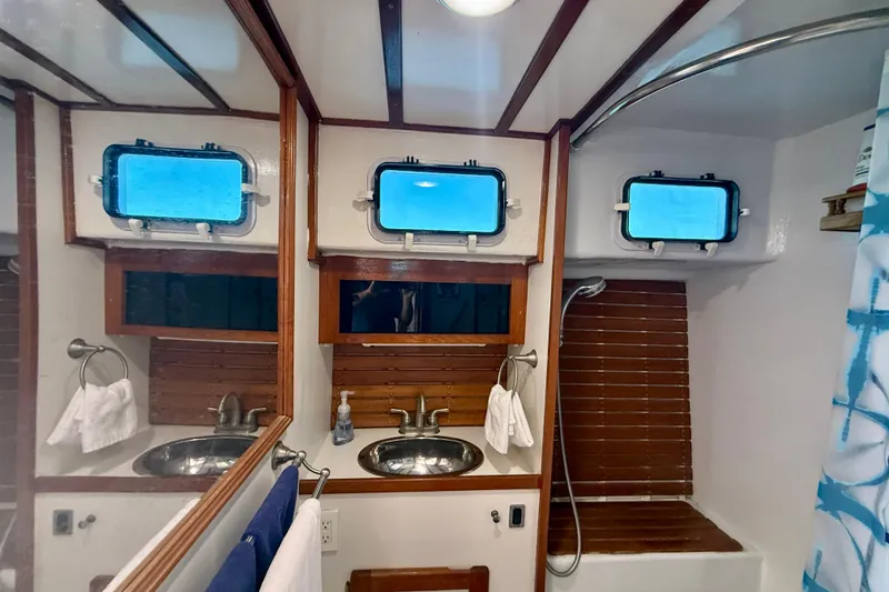 Slide: The Image of Bathroom interior of 1980 Roughwater 41 boat with dual sinks and porthole windows. - 48