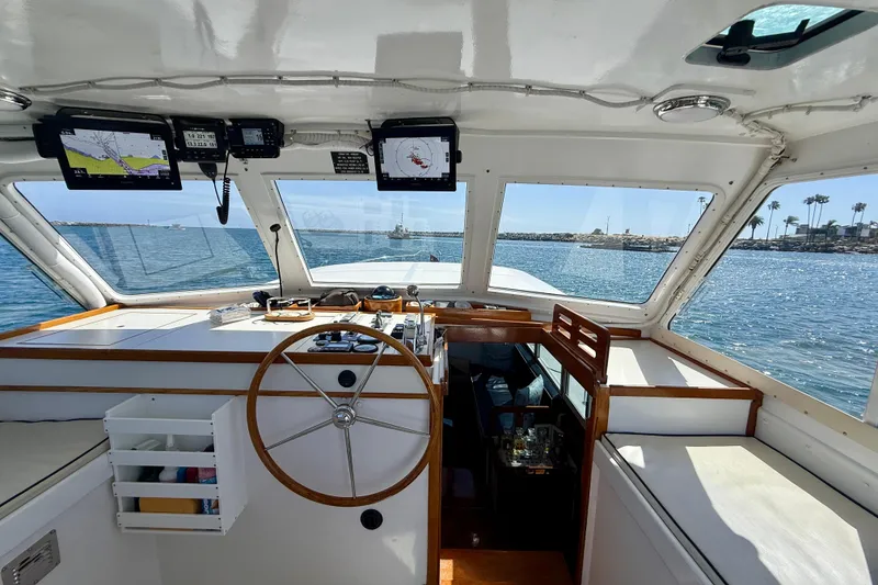 Slide: The Image of Interior view of 1980 Roughwater 41 boat cockpit with steering wheel and navigation screens. - 5