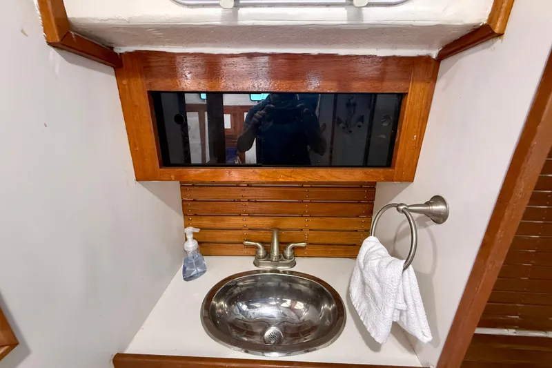 Slide: The Image of Vintage 1980 Roughwater 41 boat bathroom with stainless steel sink and wooden accents. - 51
