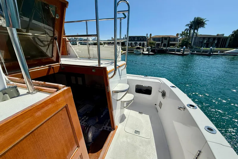 Slide: The Image of 1980 Roughwater 41 boat deck with wooden accents, overlooking a serene waterfront. - 52