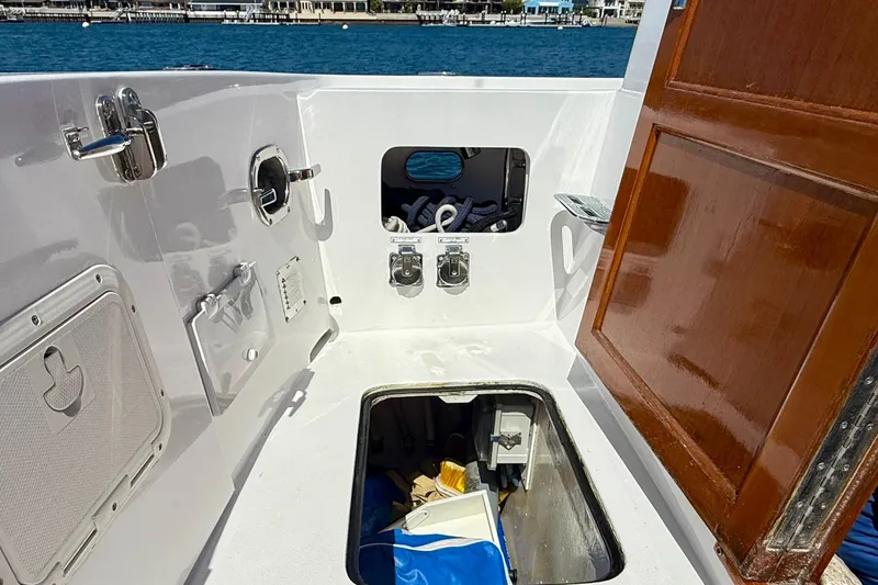 Slide: The Image of Interior view of a 1980 Roughwater 41 boat, featuring storage compartments and wooden door. - 53