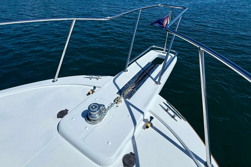 Slide: The Image of Bow of 1980 Roughwater 41 boat with railing and anchor, on calm water. - 56