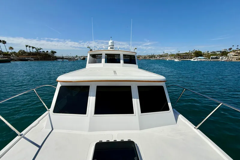 Slide: The Image of 1980 Roughwater 41 boat cruising in a scenic harbor with clear blue skies. - 57