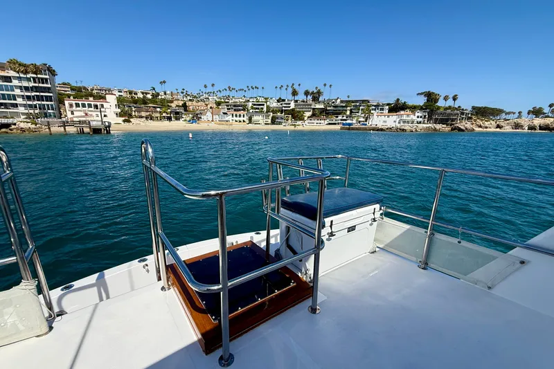 Slide: The Image of 1980 Roughwater 41 yacht deck overlooking coastal homes and clear blue water. - 58