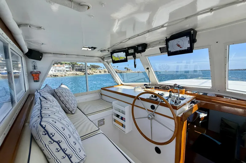 Slide: The Image of Interior of 1980 Roughwater 41 boat with helm, navigation screens, and cushioned seating. - 6