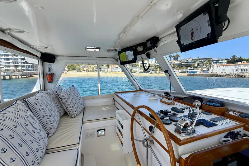 Slide: The Image of Interior of 1980 Roughwater 41 boat with helm, nautical decor, and waterfront view. - 7