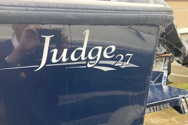 Slide: The Image of 2009 Judge 27 Center Console boat with blue hull and white lettering. - 2