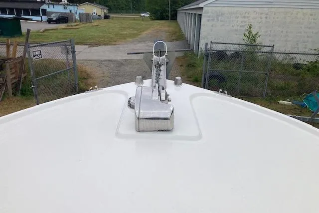 Slide: The Image of Bow view of a 2009 Judge 27 Center Console boat, anchored near a fenced area. - 8