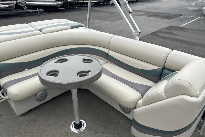Slide: The Image of 2011 South Bay 420 CR pontoon boat interior with cushioned seating and cupholder table. - 10