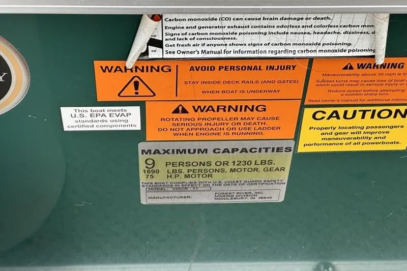 Slide: The Image of Warning labels and capacity information on a 2011 South Bay 420 CR boat. - 3