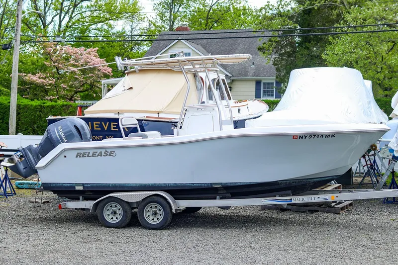 Slide: The Image of 2016 Release 208 RX boat on trailer, parked outdoors with trees and house in background. - 22