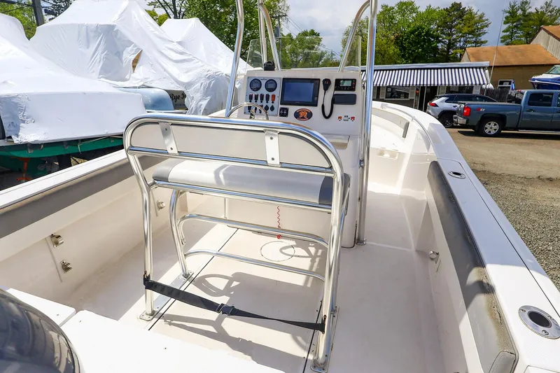 Slide: The Image of 2016 Release 208 RX boat interior with console and seating, parked outdoors. - 27