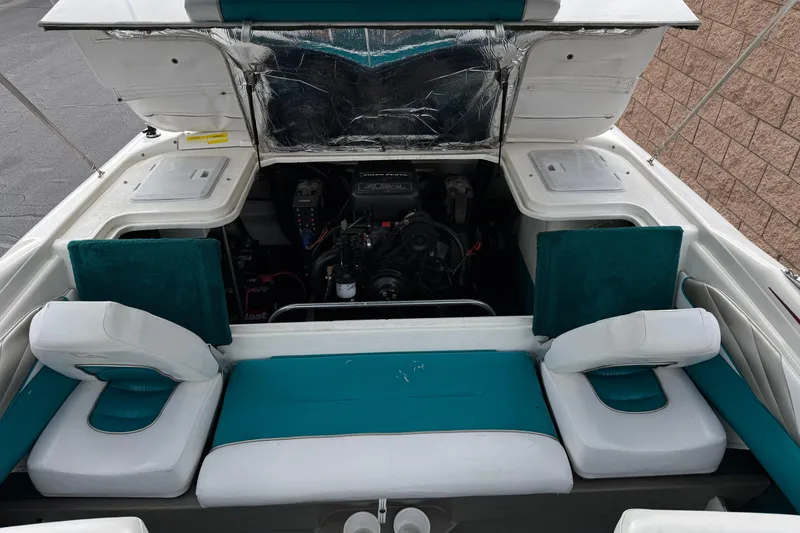 Slide: The Image of 1997 Glastron GS 185 boat interior with open engine compartment and teal seating. - 13