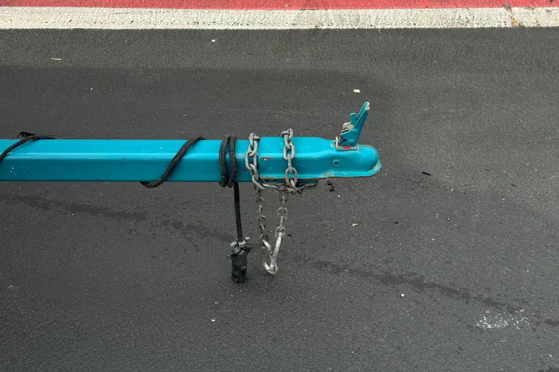 Slide: The Image of Trailer hitch of a 1997 Glastron GS 185 boat on asphalt pavement. - 23