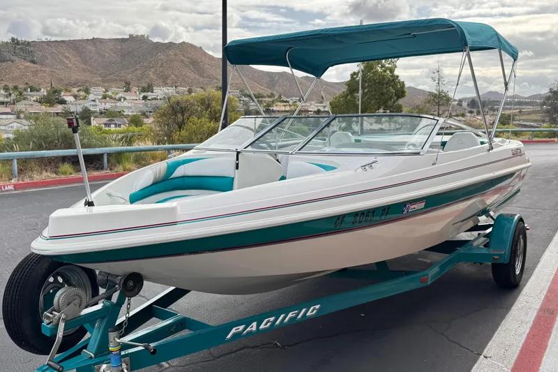 Slide: The Image of 1997 Glastron GS 185 boat on trailer with canopy, parked in scenic area. - 3