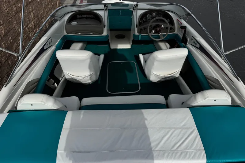 Slide: The Image of 1997 Glastron GS 185 boat interior with white and teal seating, steering wheel, and dashboard. - 7