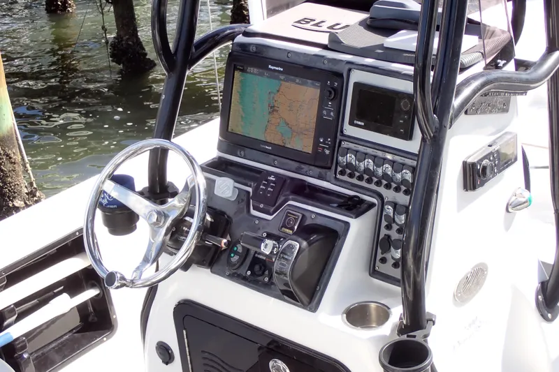 Slide: The Image of 2015 Blue Wave 2400 PureBay boat console with navigation equipment and steering wheel. - 10