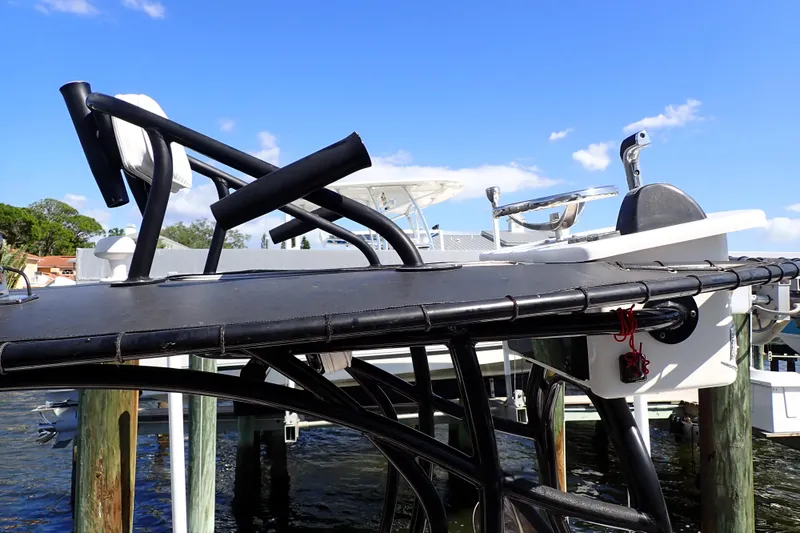 Slide: The Image of 2015 Blue Wave 2400 PureBay boat with elevated seating and steering console, docked by the water. - 7