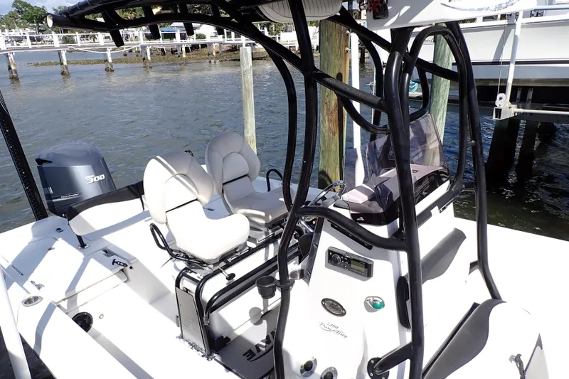 Slide: The Image of 2015 Blue Wave 2400 PureBay boat with seating and console, docked by the water. - 9