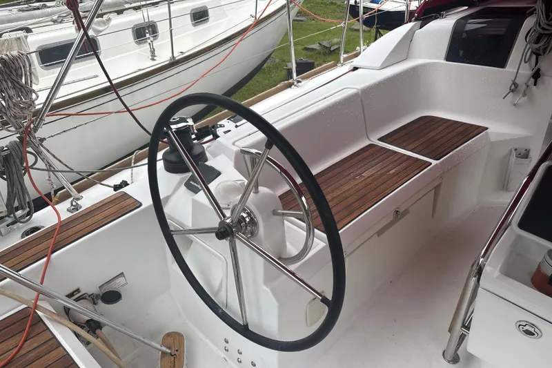 Slide: The Image of 2017 Jeanneau Sun Odyssey 389 cockpit with steering wheel and wooden seating. - 29