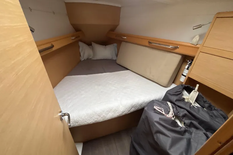 Slide: The Image of 2017 Jeanneau Sun Odyssey 389 cabin interior with bed, storage, and wooden finish. - 56