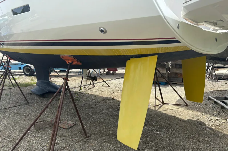 Slide: The Image of 2017 Jeanneau Sun Odyssey 389 sailboat on stands, featuring yellow rudders. - 9