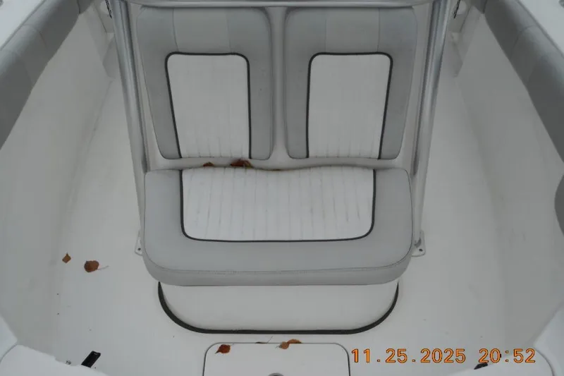 Slide: The Image of White cushioned seating on 2021 Sea Fox 228 Commander boat, with scattered leaves. - 11