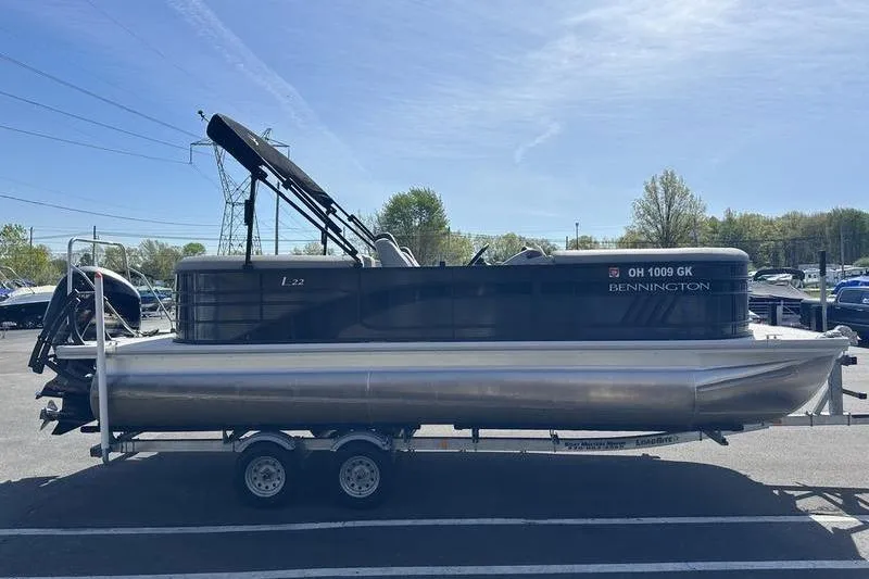 Slide: The Image of 2022 Bennington 22 LSR pontoon boat on trailer in parking lot. - 5