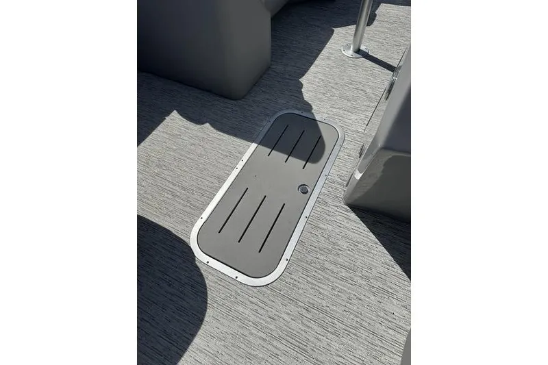 Slide: The Image of 2022 Bennington 22 LSR boat floor with storage hatch, featuring sleek gray design. - 9
