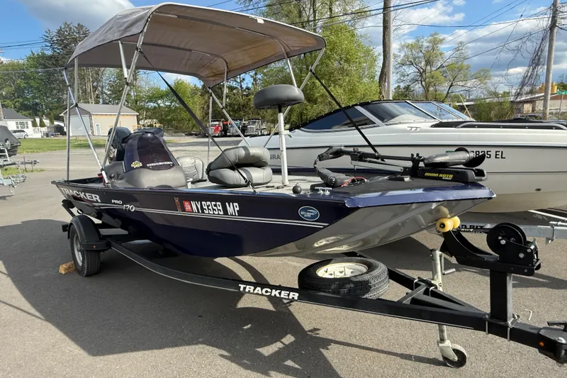 Slide: The Image of 2019 Bass Tracker Pro 17 boat with canopy on trailer, parked outdoors. - 14