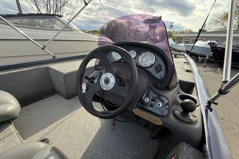 Slide: The Image of 2019 Bass Tracker Pro 17 boat dashboard with steering wheel and gauges. - 4