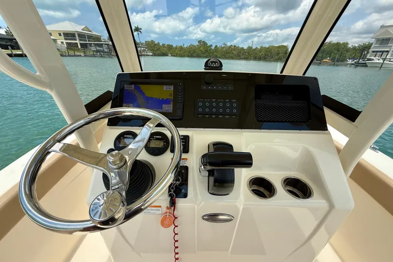 Slide: The Image of 2023 Scout 215 XSF boat helm with steering wheel, controls, and navigation display. - 16