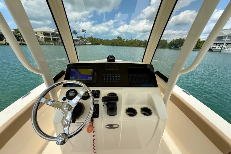 Slide: The Image of 2023 Scout 215 XSF boat dashboard with steering wheel and navigation system. - 17